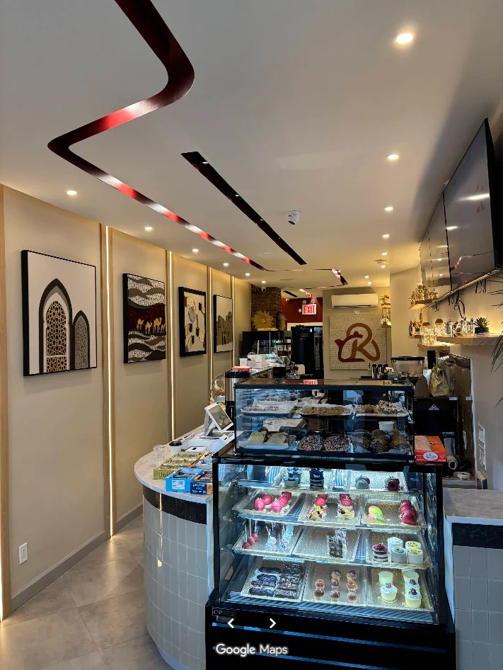 Inside Kuttley House in Greenpoint, showing the warmly lit pastry counter and café interior
